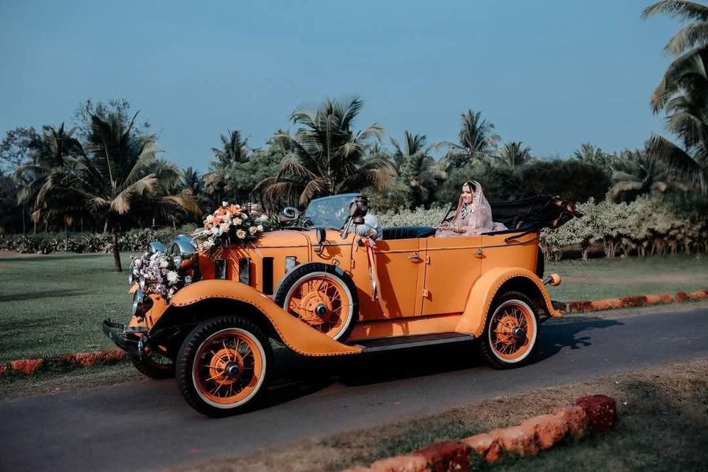 Bride arriving in the orange vintage Chevrolet