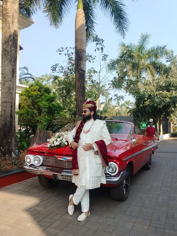 Groom in a turban leaning on the red Impala