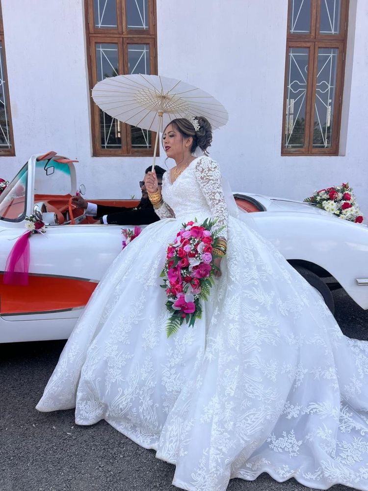 Bride with a parasol in the white Corvette