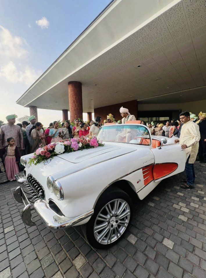 Groom arriving in the white Corvette at a baraat