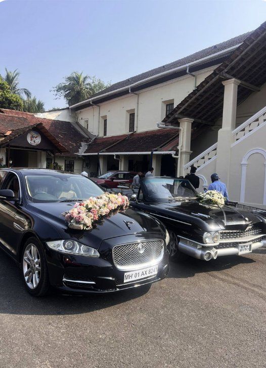 Jaguar and black Cadillac outside a Goan church